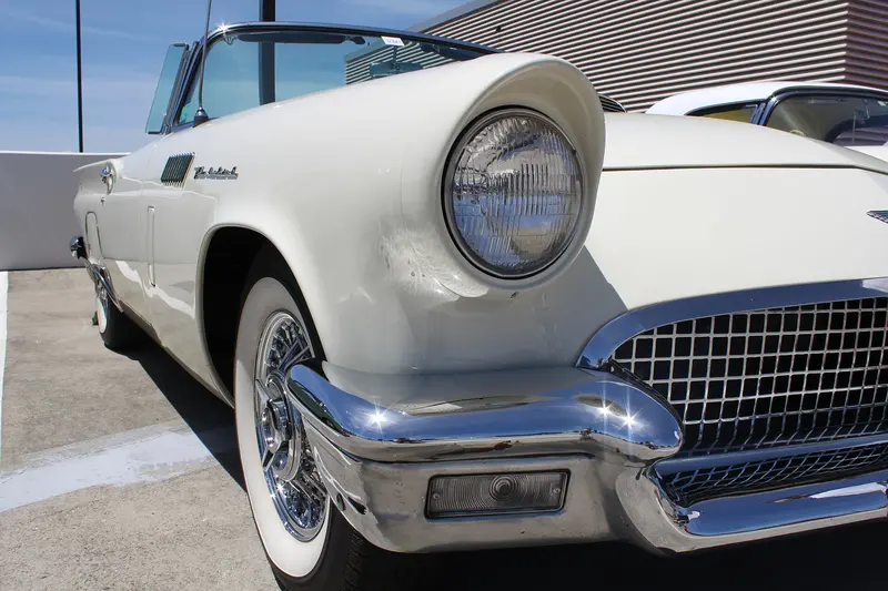 Front wing, headlamp and chrome grille of a white 1957 Ford Thunderbird